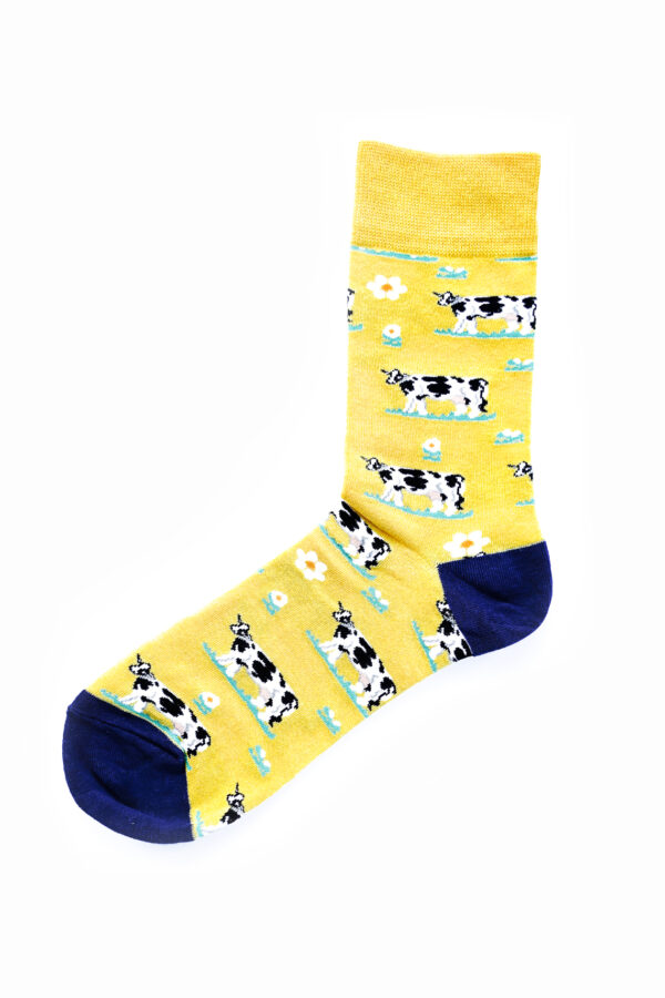 Chaussettes jaunes et bleu foncé, avec motifs de vaches noires et blanches. Taille unique.