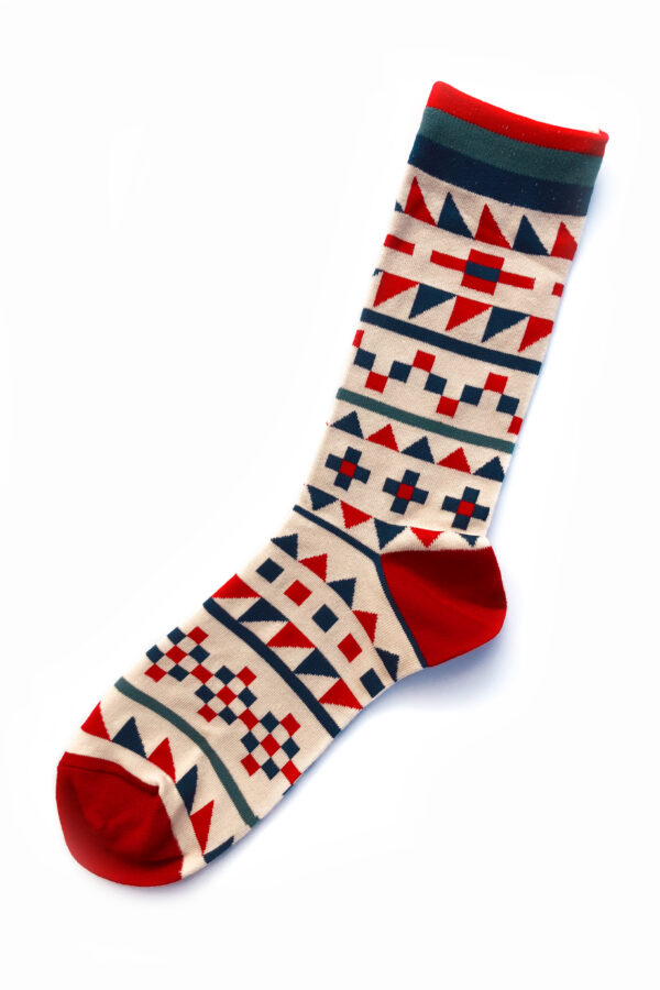 Chaussette fantaisie beige claire, avec un motif de style nordique de couleur rouge, bleu clair et bleu foncé.